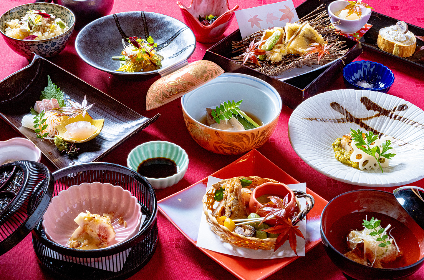 京都・綾部の料亭ゆう月が提供する秋の会席料理。紅葉をあしらった器に焼き物、天ぷら、造り、煮物、土鍋ご飯、吸物など、旬の味覚を彩り豊かに盛り込んだ日本料理コース。
