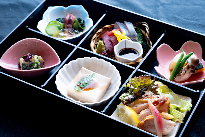舞鶴港水揚げのお造り、手作りごま豆腐、季節の和え物・酢の物・炊き合わせ・上林鶏の岩塩焼きを盛り込んだ、料亭ゆう月の団体旅行向け松花堂弁当