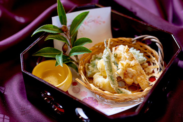 上林鶏の香り揚げとアーモンド包みの二色揚げ。旬野菜の天ぷらを籠盛りにし、ヒマラヤ岩塩と椿の小枝を添えた冬の会席料理の油物