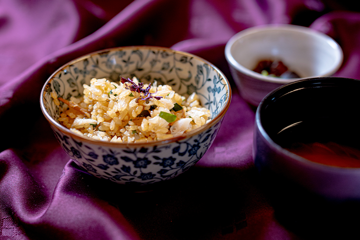 舞鶴産干しガレイのほぐし身と舞鶴わかめを使った炊き込みご飯を、文様の茶碗に盛り付けた和食料理。