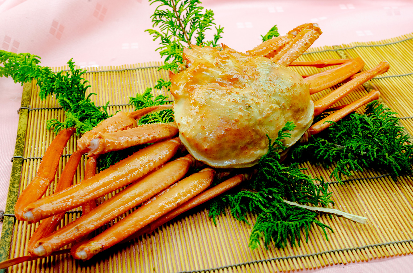 香住港で水揚げされた香住ガニの姿盛り。竹簾に盛り付け、緑の葉で彩られた冬の味覚。