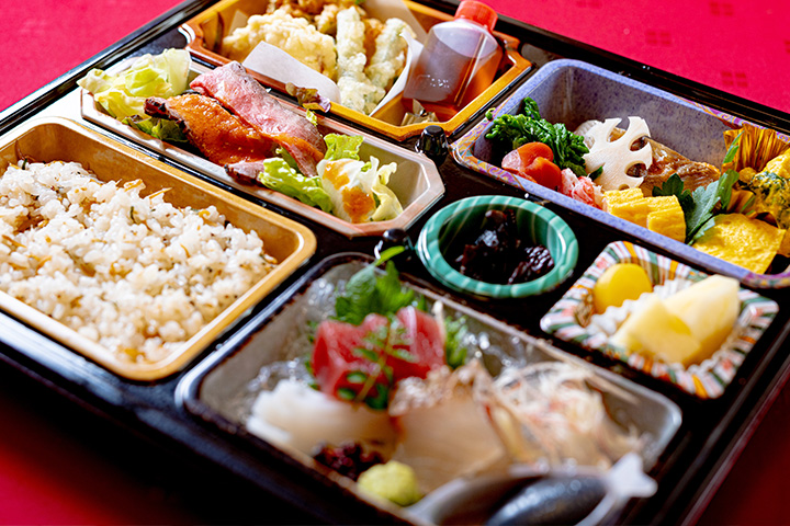 料亭ゆう月の仕出し弁当イメージ。季節の天ぷらや炊き込みご飯、煮物などを丁寧に盛り込んだ会席仕立ての宅配弁当