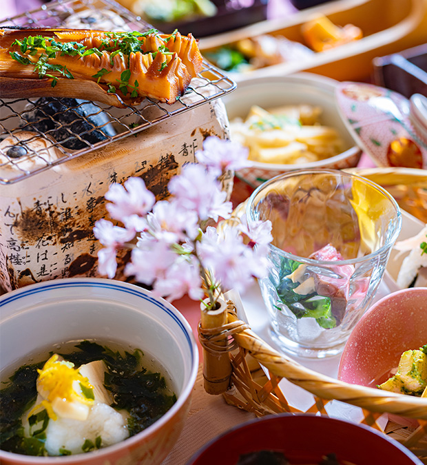 春の会席料理、炭火で焼いた筍と桜の演出、吸物や小鉢が並ぶ華やかな和食膳